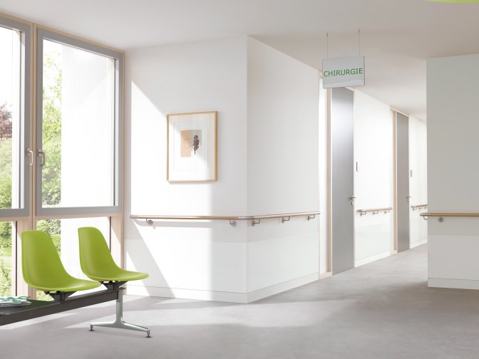 Hospital corridor equipped with a beech handrail and impact protection at the corners
