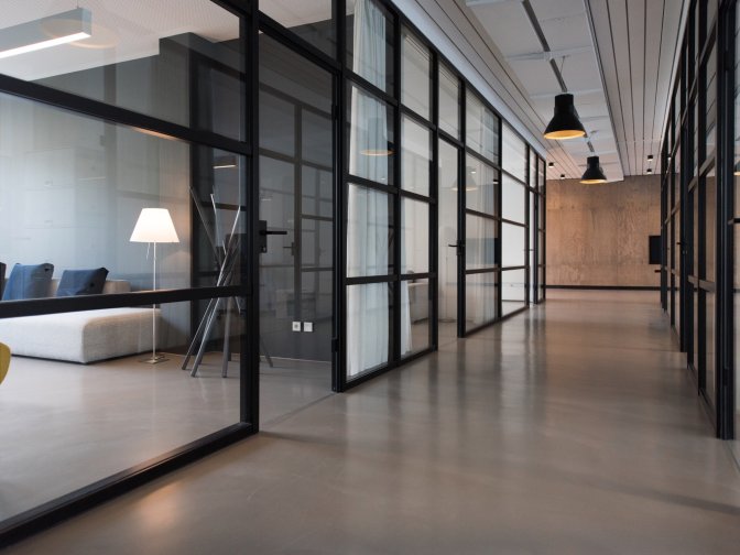 Corridor in an office building with transparent doors to various offices